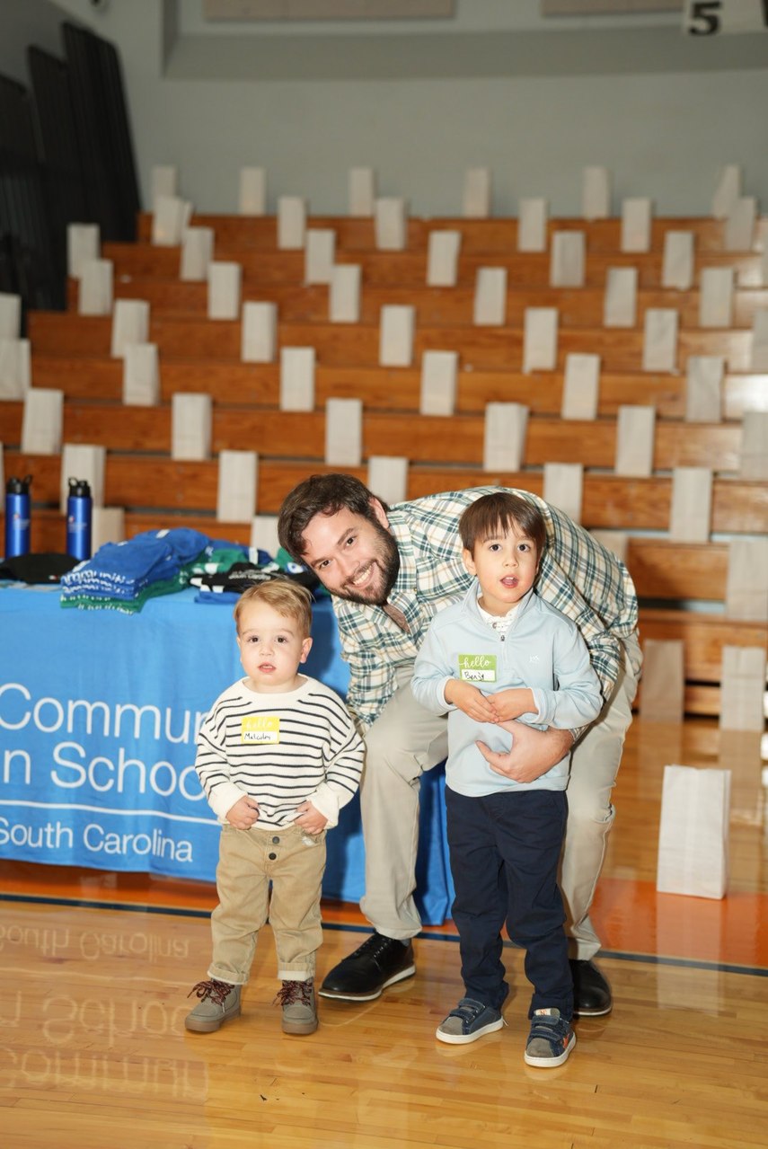 Family beside a Communities In Schools of South Carolina table and luminary display; organizer reference photo.