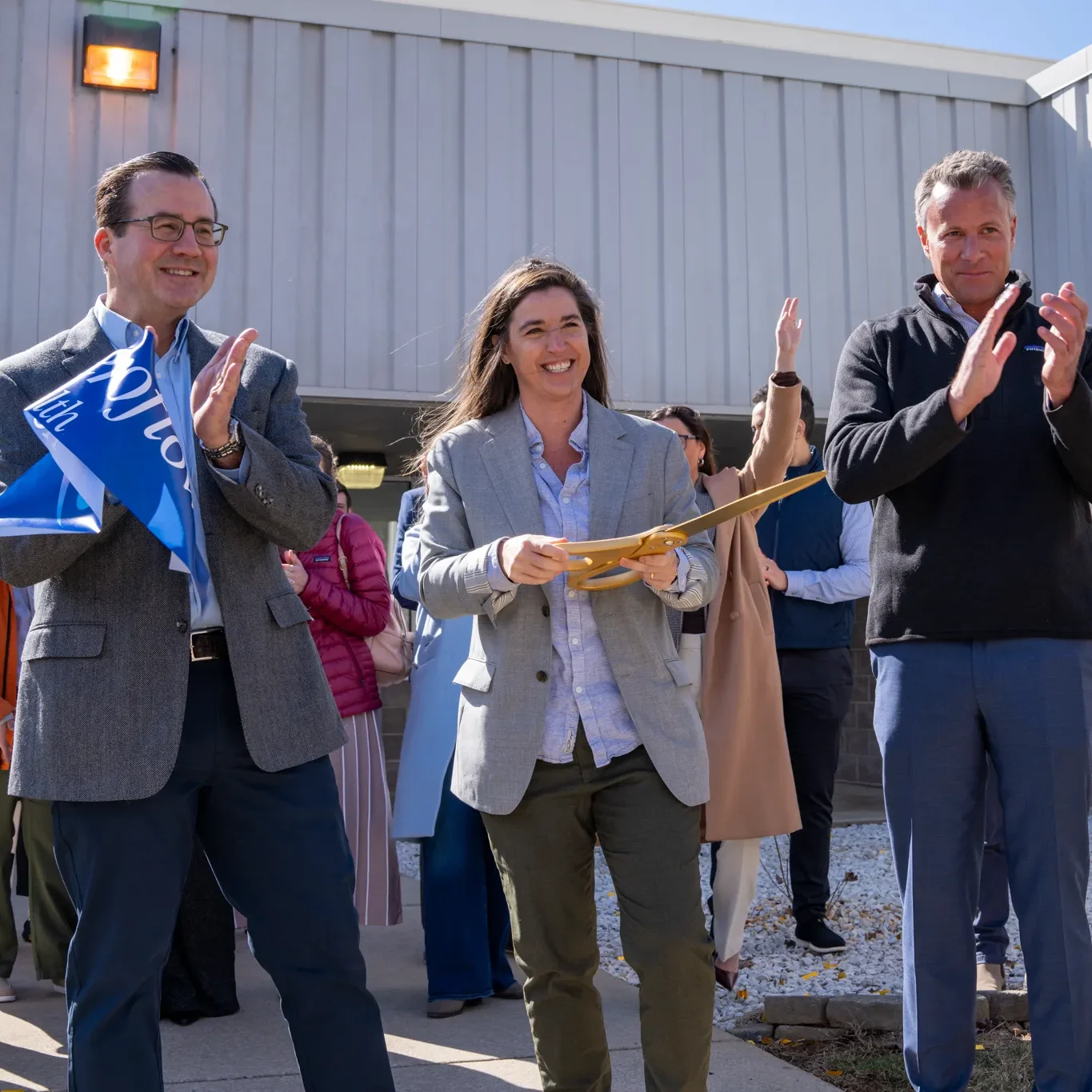 Aeroflow Health ribbon-cutting ceremony outside a company building.