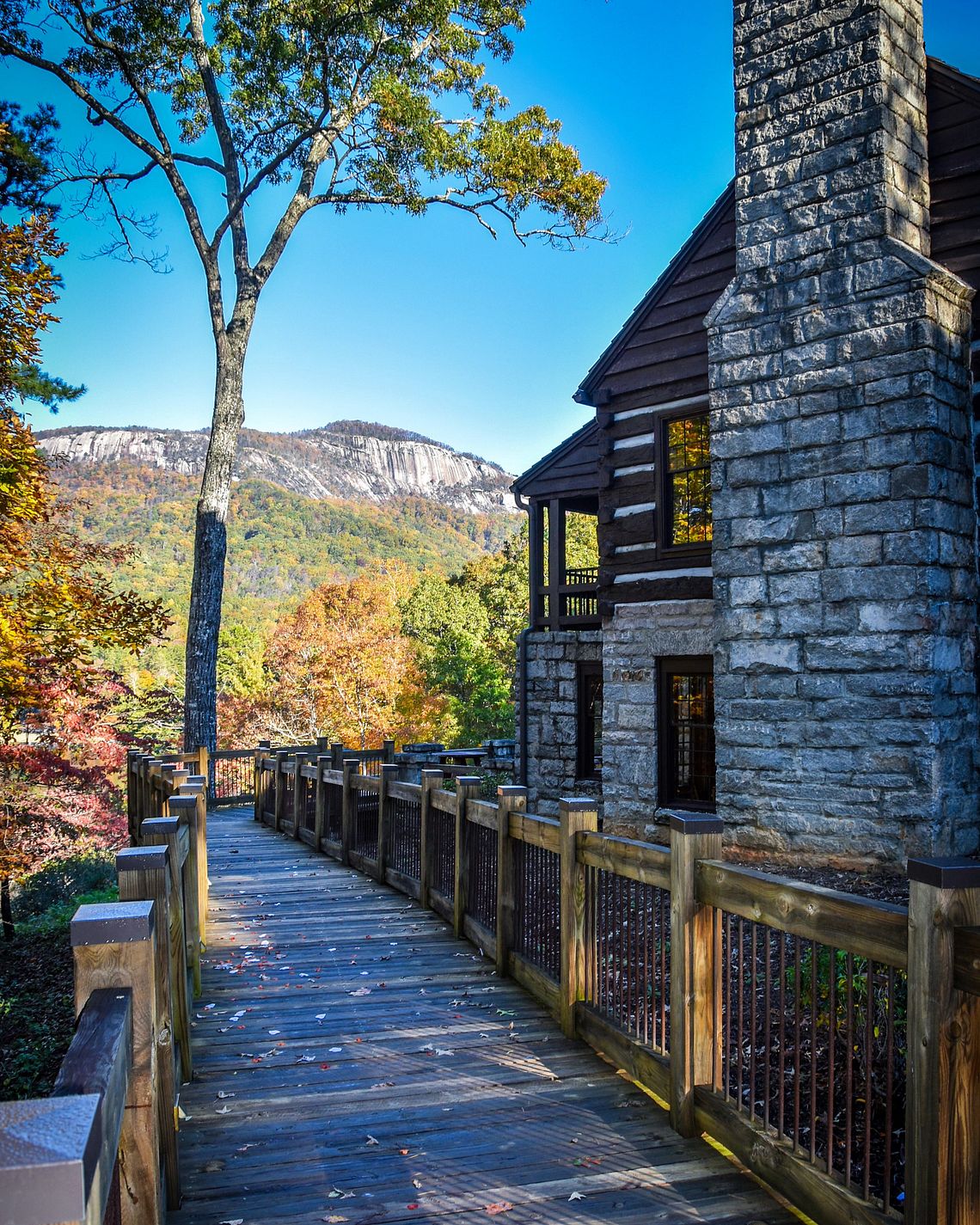 Stone chimney and wooden walkway at Gaines Lodge with Table Rock Mountain behind