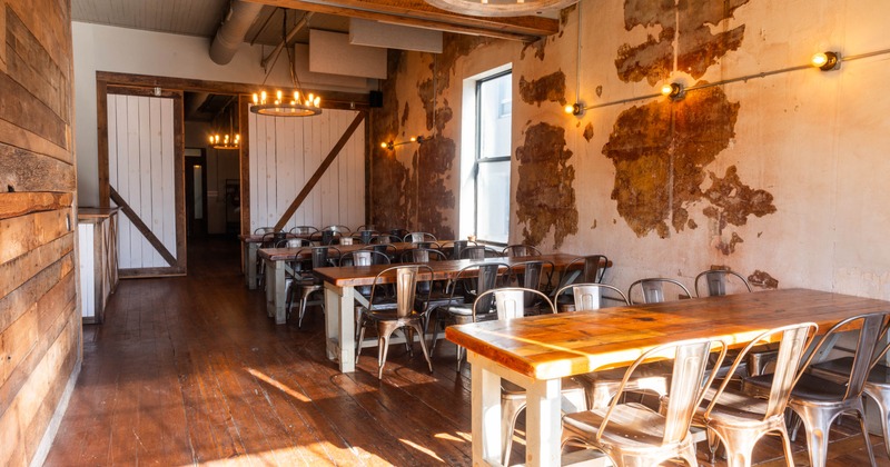 Rhubarb private dining room with wooden tables, metal chairs, and warm lighting.